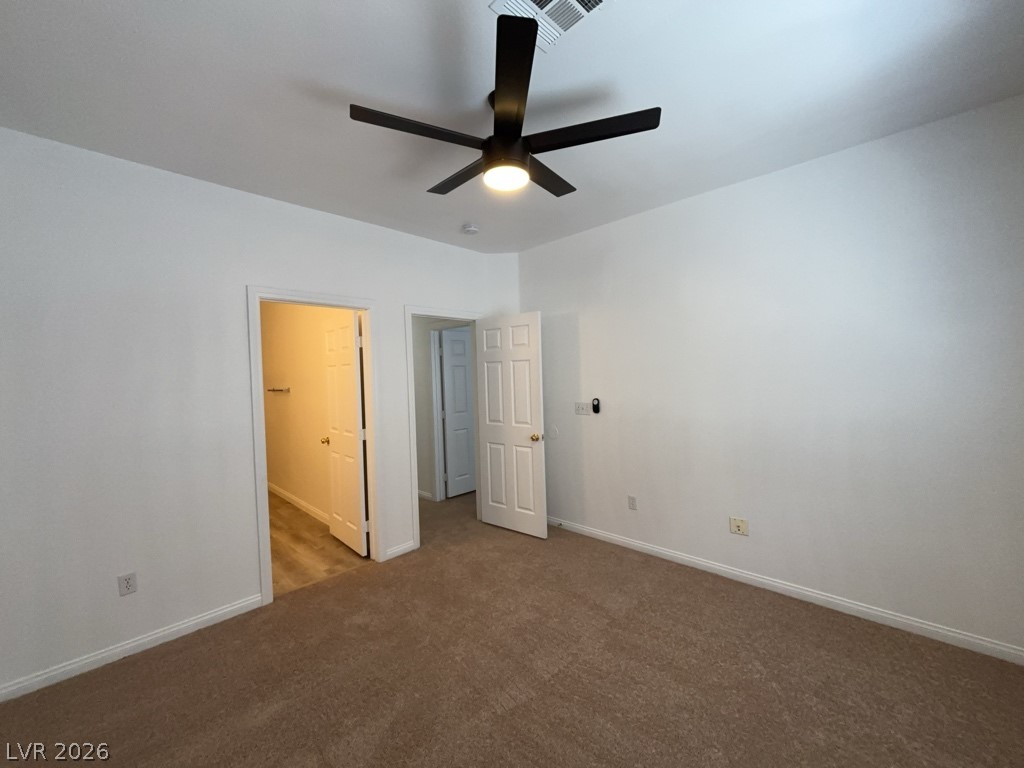 4915 East Russell Road, Unit 144 Las Vegas, NV 89120 - Photo 10 of 14 Unfurnished bedroom featuring ceiling fan, dark carpet, and ensuite bathroom