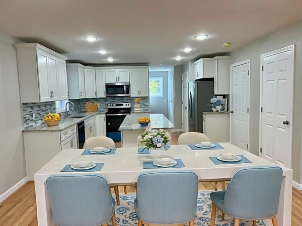 1 Heritage Lane Monson, MA 01057 - Photo 3 of 23 a kitchen with stainless steel appliances kitchen island granite countertop a dining table chairs and a refrigerator
