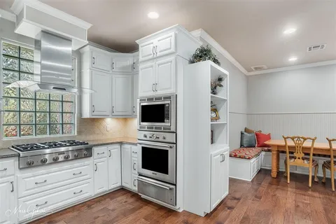 a kitchen with stainless steel appliances a white stove top oven and a refrigerator