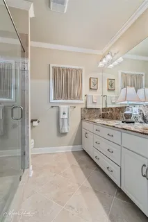 a spacious bathroom with a granite countertop sink a mirror and a bathtub