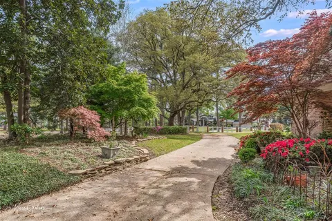 a pathway of a house with a yard and sitting area