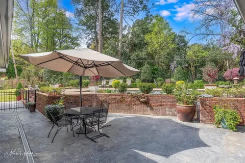 a view of a patio with chairs and a small yard