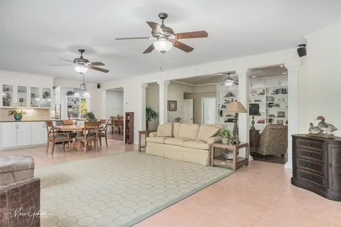 a living room with furniture kitchen view and a chandelier