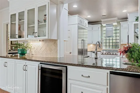 a kitchen with stainless steel appliances sink large window and cabinets