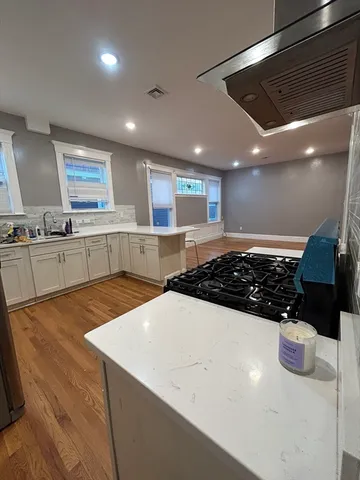 a large kitchen with stainless steel appliances a large counter top