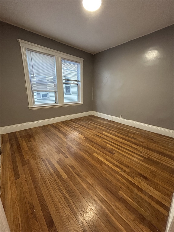 36 Hosmer Street, Unit 2 Boston, MA 02126 - Photo 23 of 30 a view of an empty room with wooden floor and a window