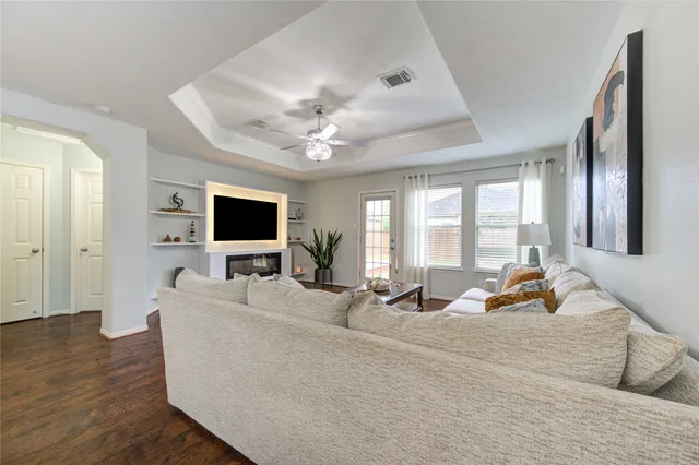 a living room with furniture a flat screen tv and a large window