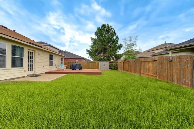 a view of a house next to a big yard and large trees