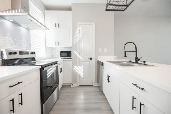 a kitchen with a sink and a stove top oven