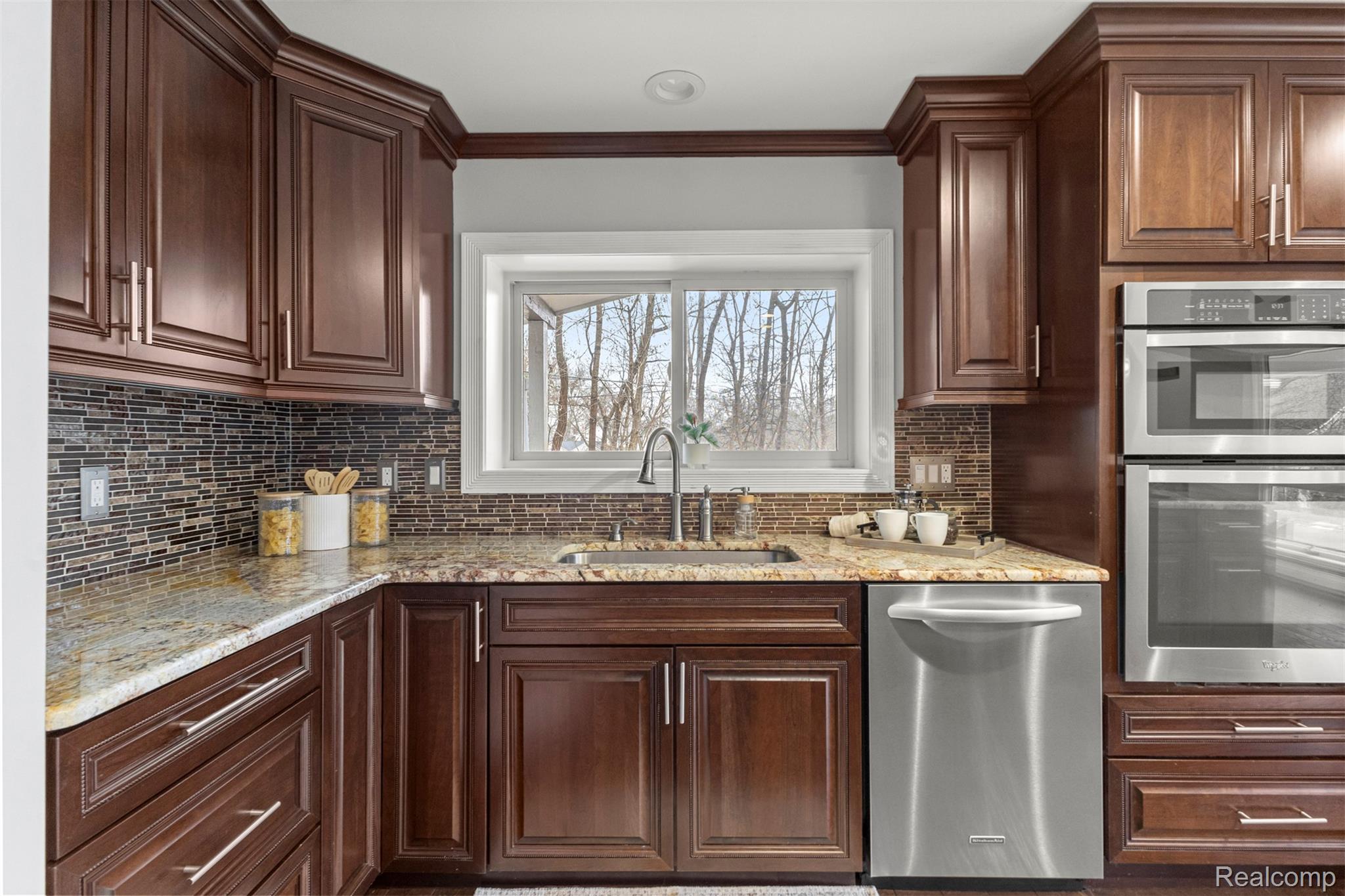45401 West 9 Mile Road Novi, MI 48374 - Photo 13 of 67 Kitchen with stainless steel appliances, light stone counters, crown molding, and dark brown cabinetry