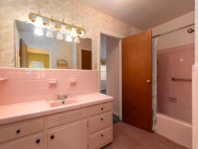 a bathroom with a sink a large mirror and shower