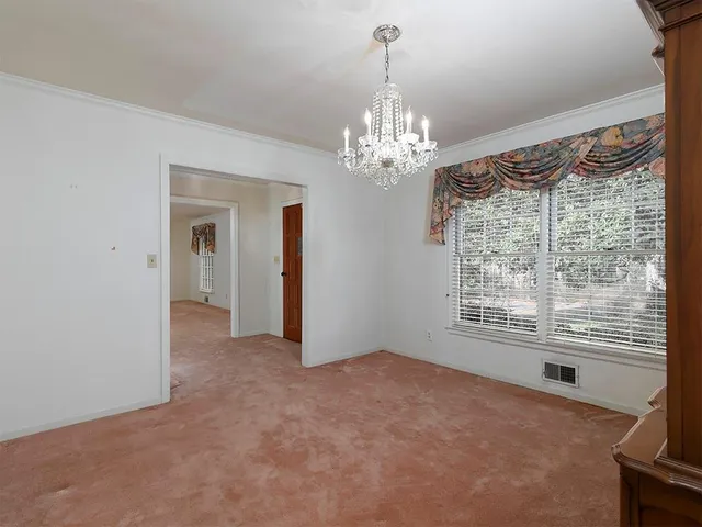 a view of a livingroom with a chandelier curtains and large windows