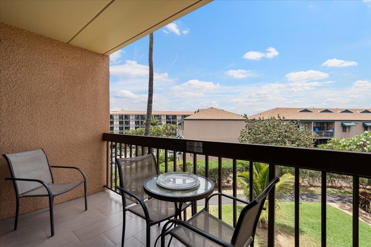 2191 South Kihei Road, Unit 2303 Kihei, HI 96753 - Photo 31 of 43 a view of a balcony with a table and chairs and wooden floor