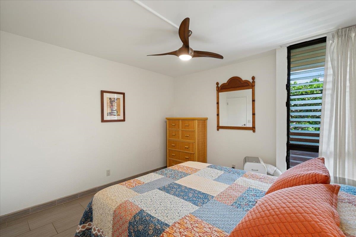 2191 South Kihei Road, Unit 2303 Kihei, HI 96753 - Photo 38 of 43 a bedroom with a bed and a chandelier