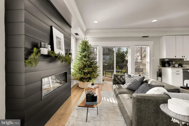 a living room with stainless steel appliances furniture and a view of kitchen