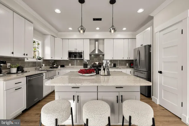 a kitchen with stainless steel appliances granite countertop a white cabinets and wooden floor
