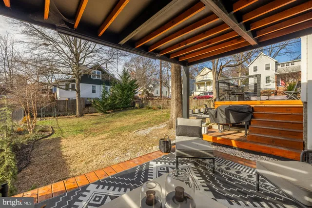 a backyard of a house with barbeque oven table and chairs