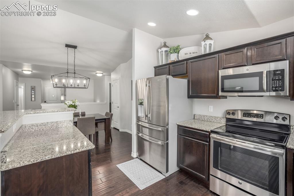 17835 Mining Way Monument, CO 80132 - Photo 12 of 49 a kitchen with stainless steel appliances granite countertop a sink stove and refrigerator