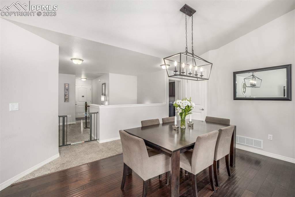 17835 Mining Way Monument, CO 80132 - Photo 18 of 49 a dining room with furniture a chandelier and wooden floor