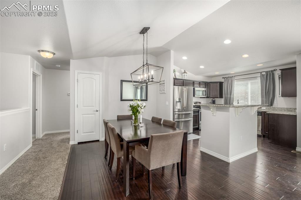 17835 Mining Way Monument, CO 80132 - Photo 19 of 49 a view of a dining room and livingroom with furniture wooden floor kitchen chandelier