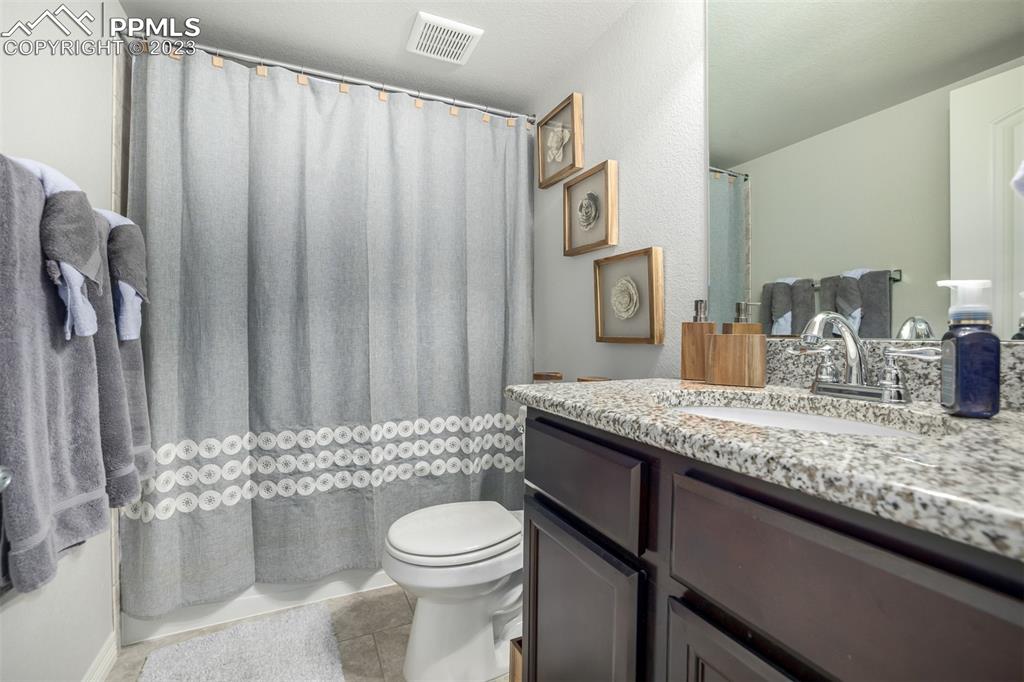 17835 Mining Way Monument, CO 80132 - Photo 30 of 49 a bathroom with a granite countertop sink toilet and shower