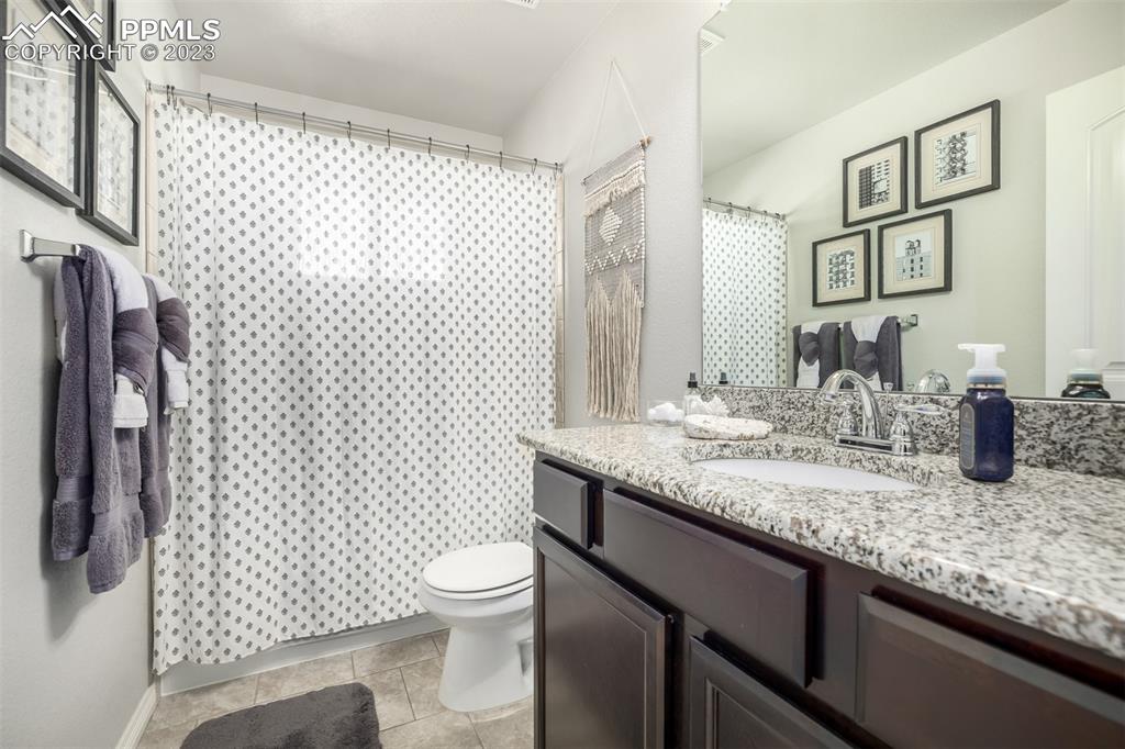 17835 Mining Way Monument, CO 80132 - Photo 32 of 49 a bathroom with a granite countertop sink toilet and shower