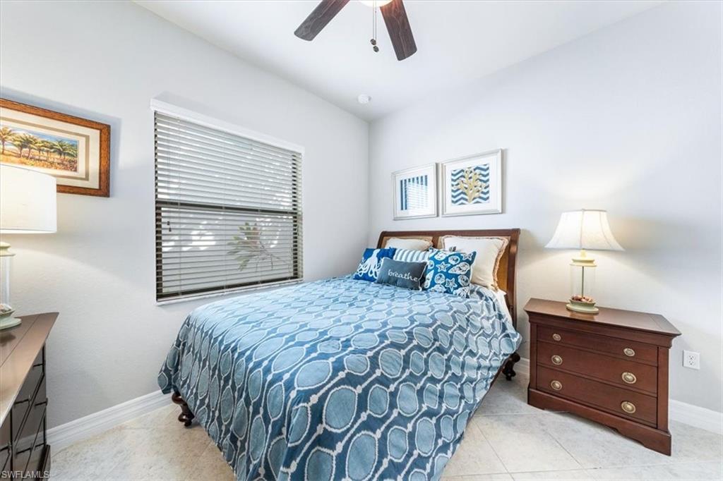 13576 Mandarin Circle Naples, FL 34109 - Photo 18 of 24 a bedroom with a bed and a lamp on table