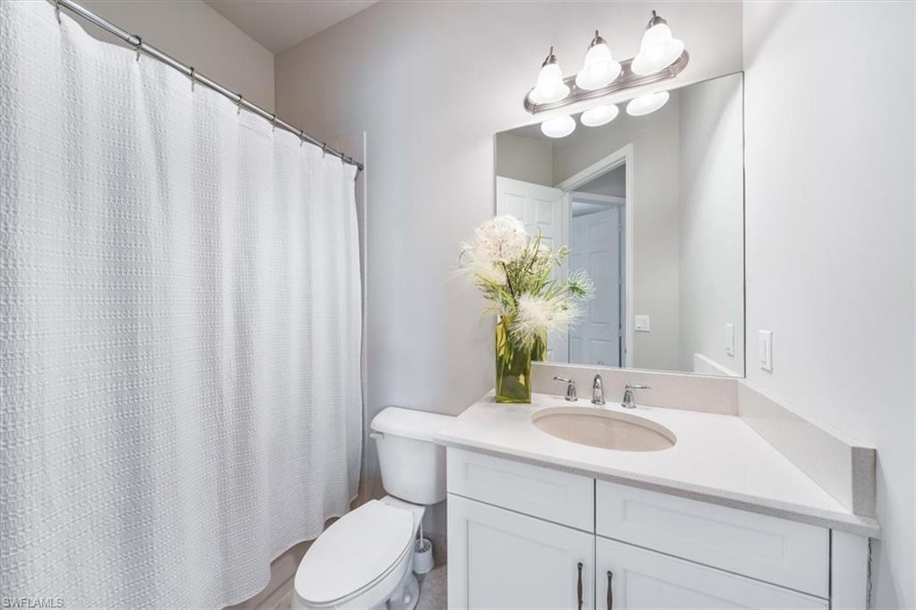13576 Mandarin Circle Naples, FL 34109 - Photo 19 of 24 a bathroom with a sink vanity granite and toilet