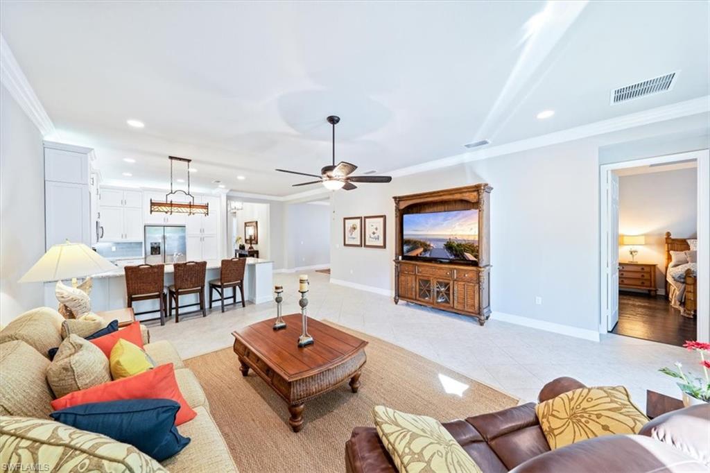 13576 Mandarin Circle Naples, FL 34109 - Photo 4 of 24 a living room with furniture and a flat screen tv