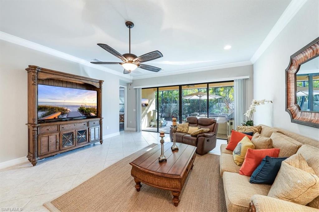 13576 Mandarin Circle Naples, FL 34109 - Photo 5 of 24 a living room with furniture a flat screen tv and a large window