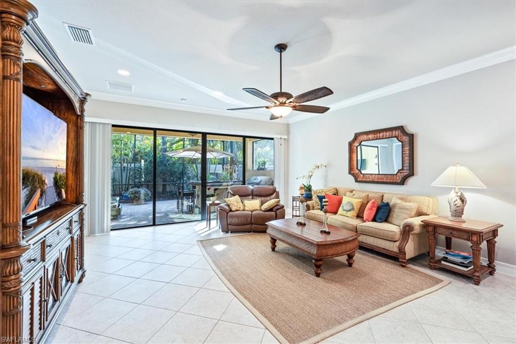 13576 Mandarin Circle Naples, FL 34109 - Photo 6 of 24 a living room with furniture and a flat screen tv