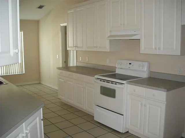a kitchen with white cabinets and white appliances