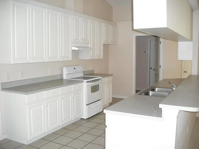 a kitchen with granite countertop white cabinets and white appliances