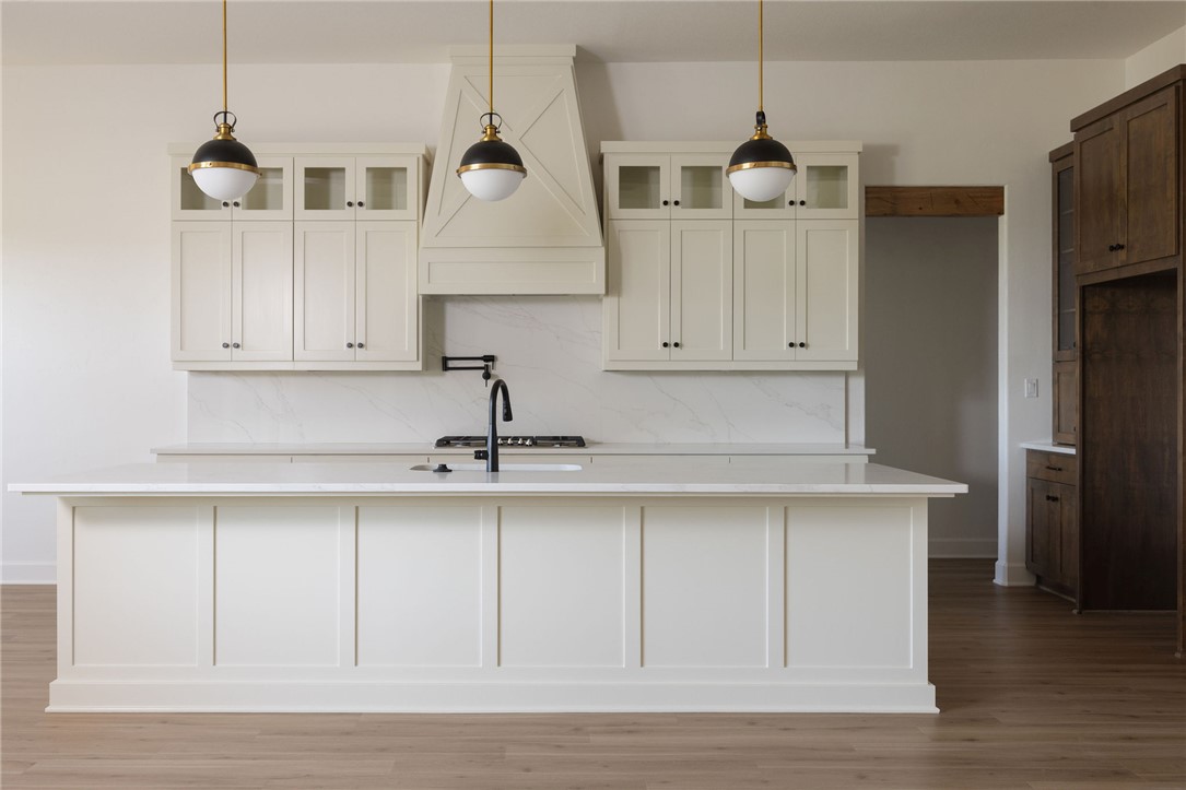 4760 Coral River Road College Station, TX 77845 - Photo 9 of 34 a kitchen with stainless steel appliances granite countertop a sink a refrigerator a stove and white cabinets with wooden floor
