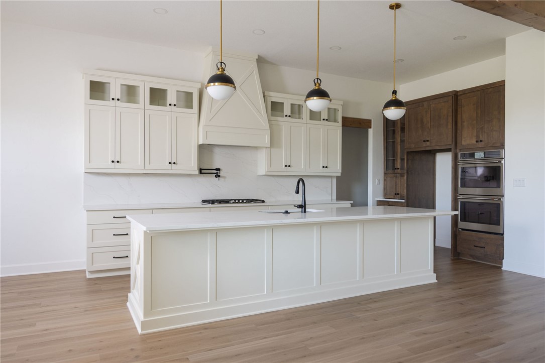4760 Coral River Road College Station, TX 77845 - Photo 10 of 34 a kitchen with stainless steel appliances granite countertop a sink a stove a refrigerator and island with wooden floor