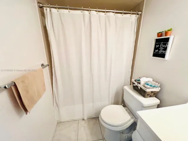 a white toilet sitting next to a shower curtain