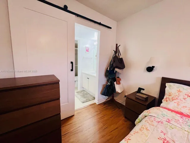 a bedroom with two beds and wooden floor