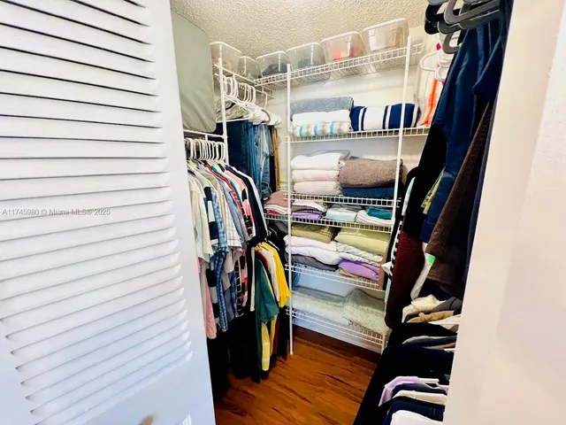 a view of walk in closet with clothes and shoes
