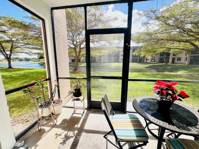 a view of a dining room with furniture water view and a floor to ceiling window