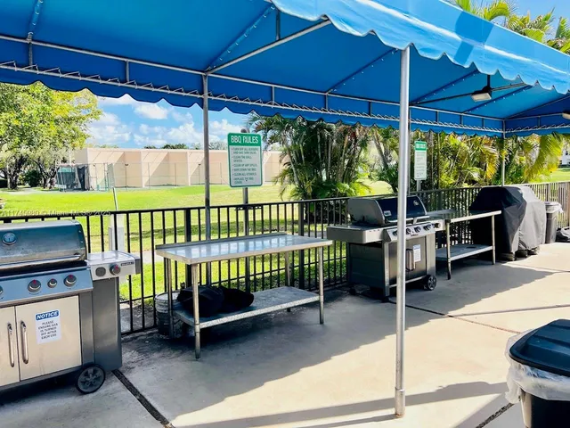 a view of a patio with table and chairs under an umbrella