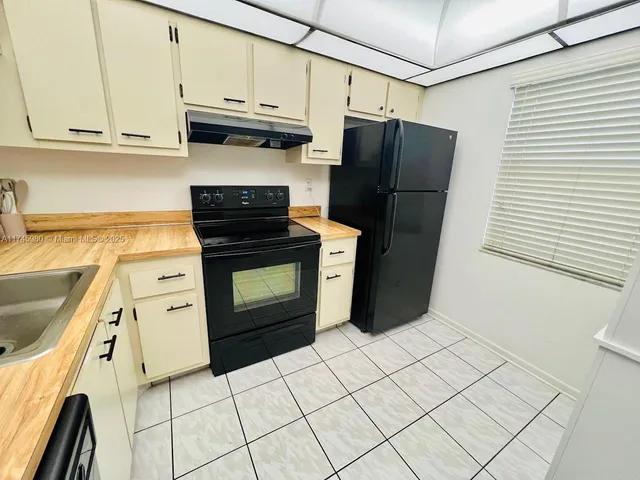 a kitchen with stainless steel appliances granite countertop a refrigerator stove and sink