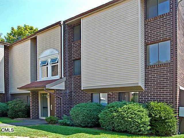7 Padanaram Road, Unit 74 Danbury, CT 06811 - Photo 1 of 1 a front view of a house with a yard and potted plants