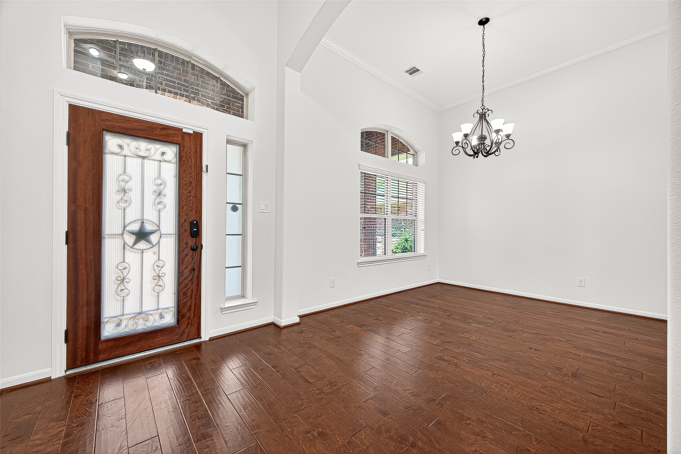 138 South Sawbridge Circle Spring, TX 77389 - Photo 4 of 37 an empty room with wooden floor chandelier and windows