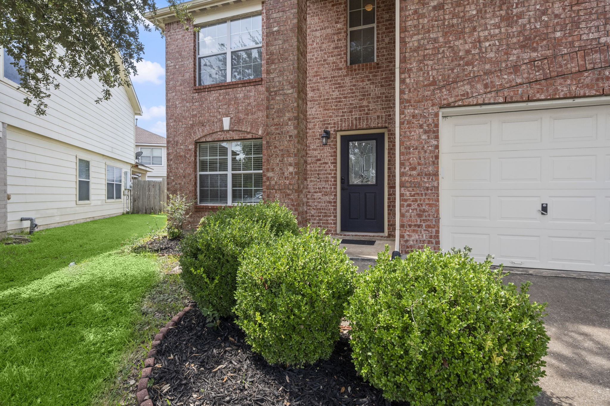 Easy maintenance landscape, new mulch, gorgeous oak tree, pretty navy blue door and a keyless entry lock say "WELCOME"!