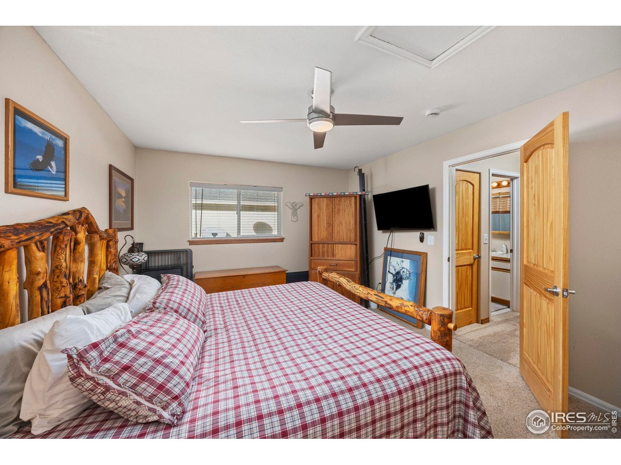 210 2nd Street Mead, CO 80542 - Photo 20 of 29 a bedroom with a large bed a flat tv screen and a dresser