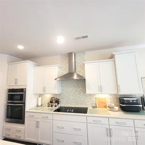 a kitchen with granite countertop a sink a stove and cabinets
