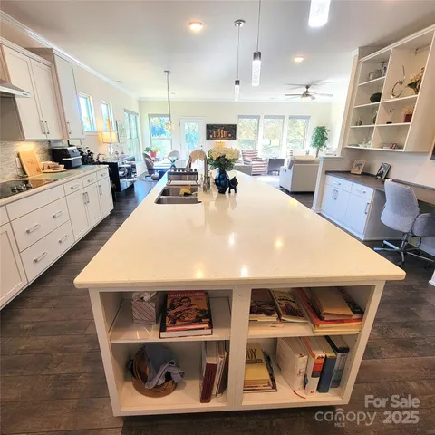 a large white kitchen with lots of wooden furniture