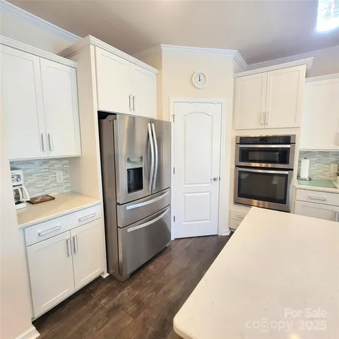 a kitchen with stainless steel appliances a refrigerator and a stove top oven
