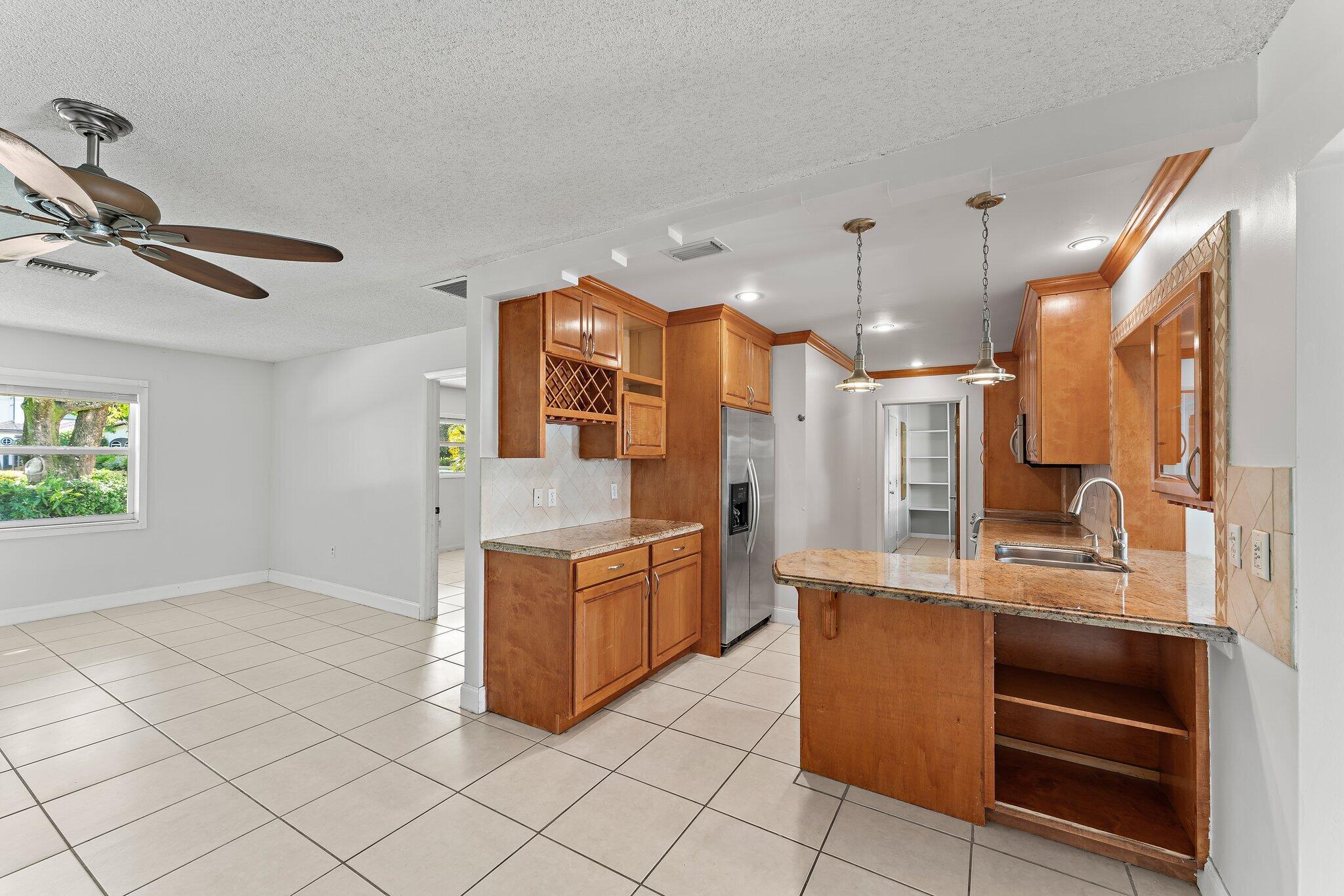 243 West Riverside Drive Jupiter, FL 33469 - Photo 20 of 67 a large kitchen with stainless steel appliances kitchen island granite countertop a refrigerator and a stove top oven