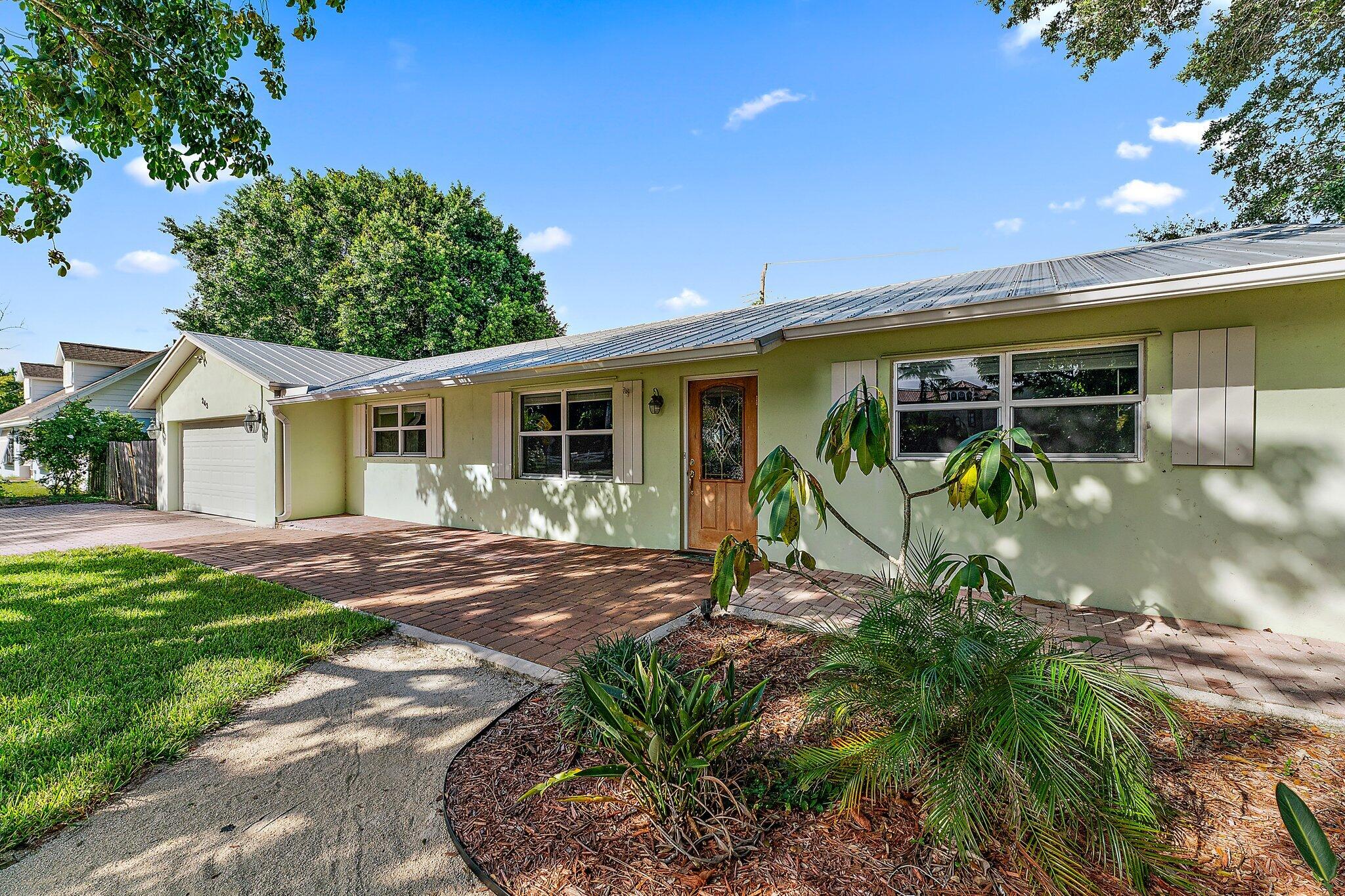 243 West Riverside Drive Jupiter, FL 33469 - Photo 2 of 67 a view of a backyard with plants and a patio
